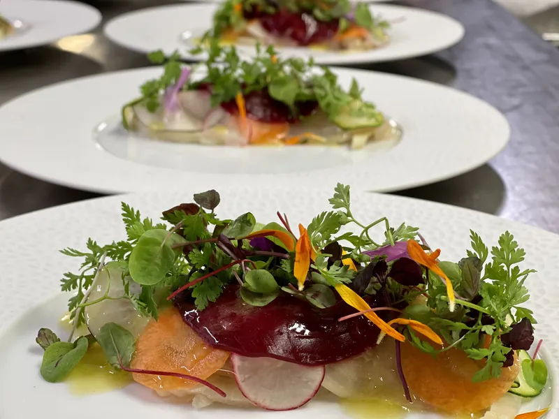 Entrée gastronomique : légumes croquants, jeunes pousses et fleurs comestibles