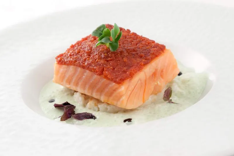 Pavé de saumon en croûte de tomates, riz crémeux et sauce aux herbes